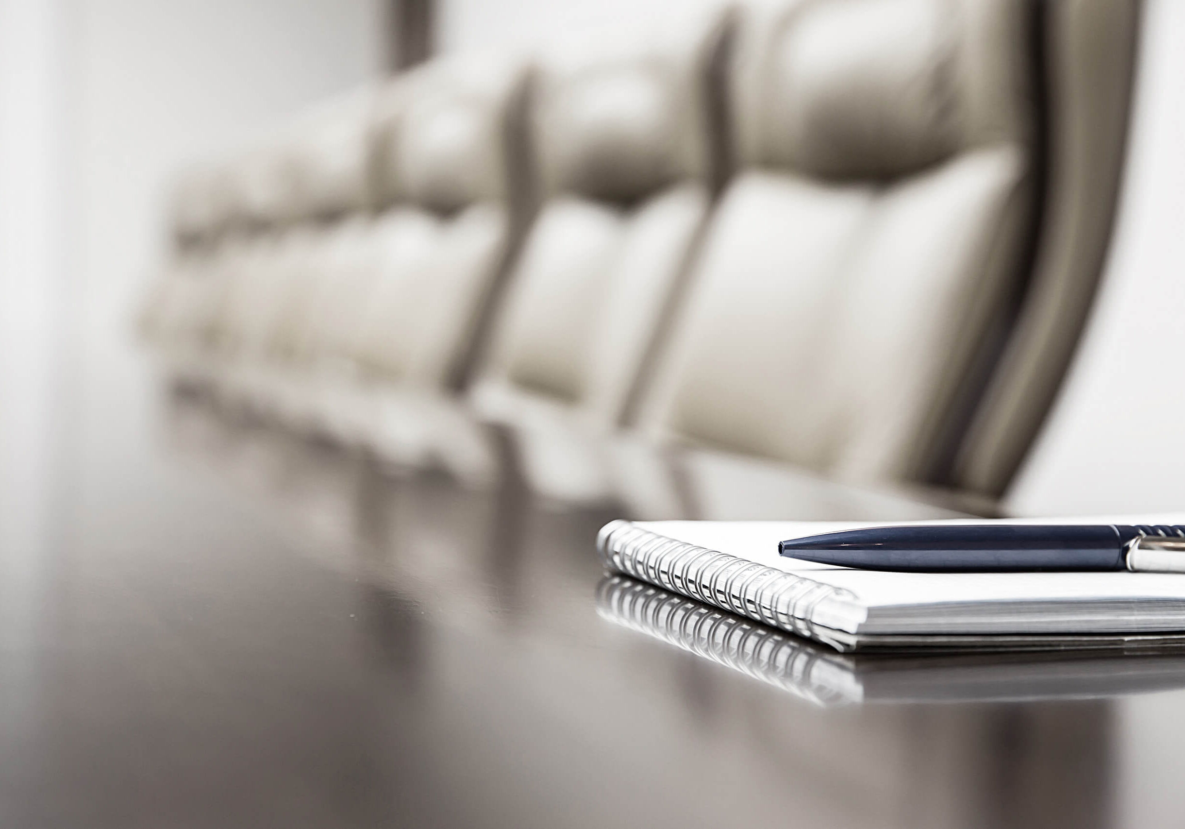 Closeup of notepad for agenda kept on table in empty corporate conference room before business meeting